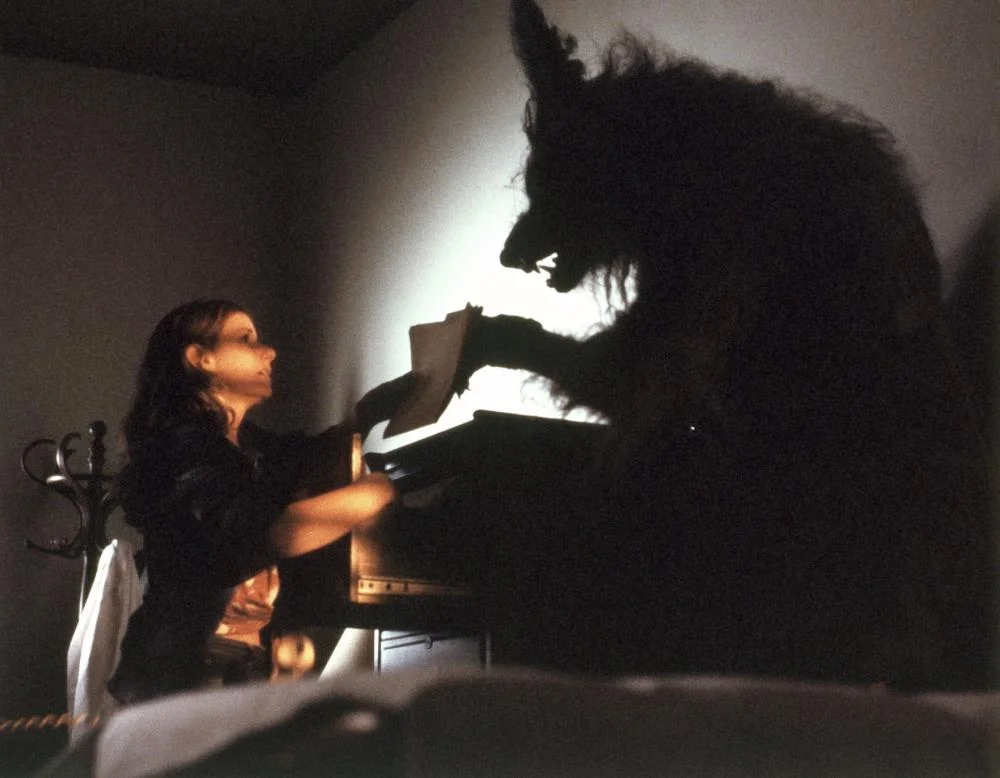 a woman standing near a werewolf