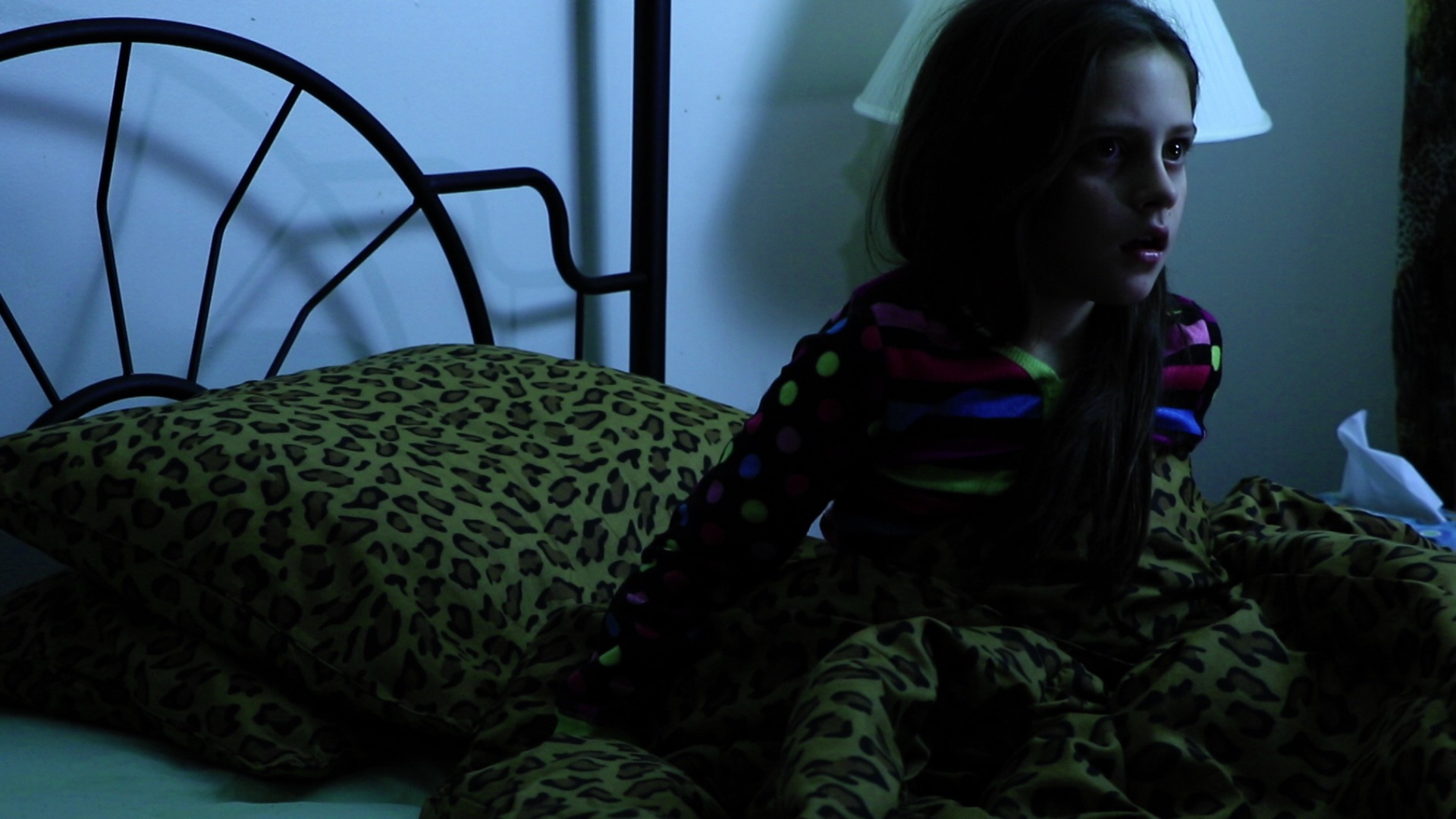 GIrl sits up in bed frightened in Where Demons Dwell