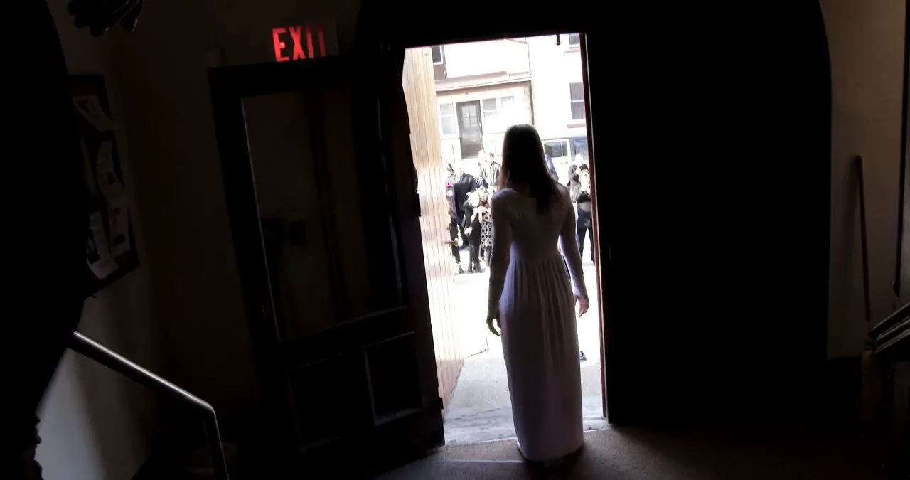 Girl in shadowy doorway in Godforsaken