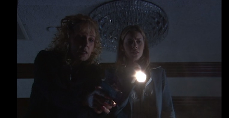 Women shine flashlight into darkness