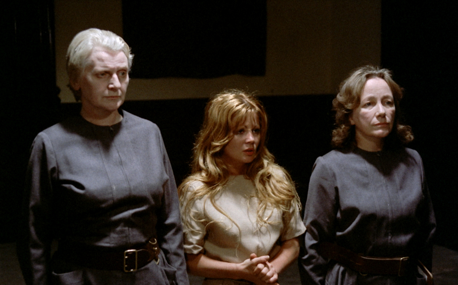 Girl between cold-looking matrons