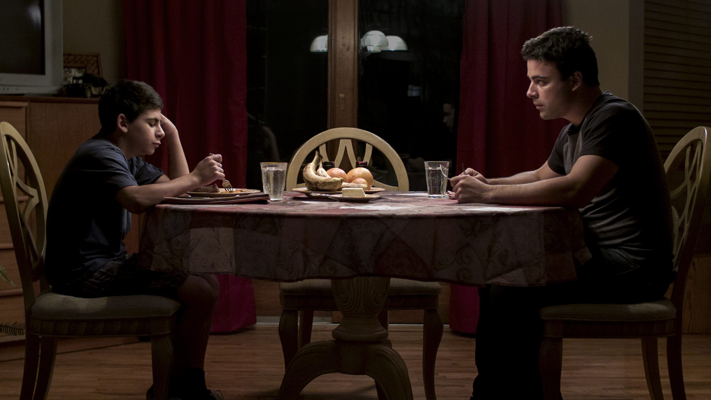 Boy and father talk over dinner