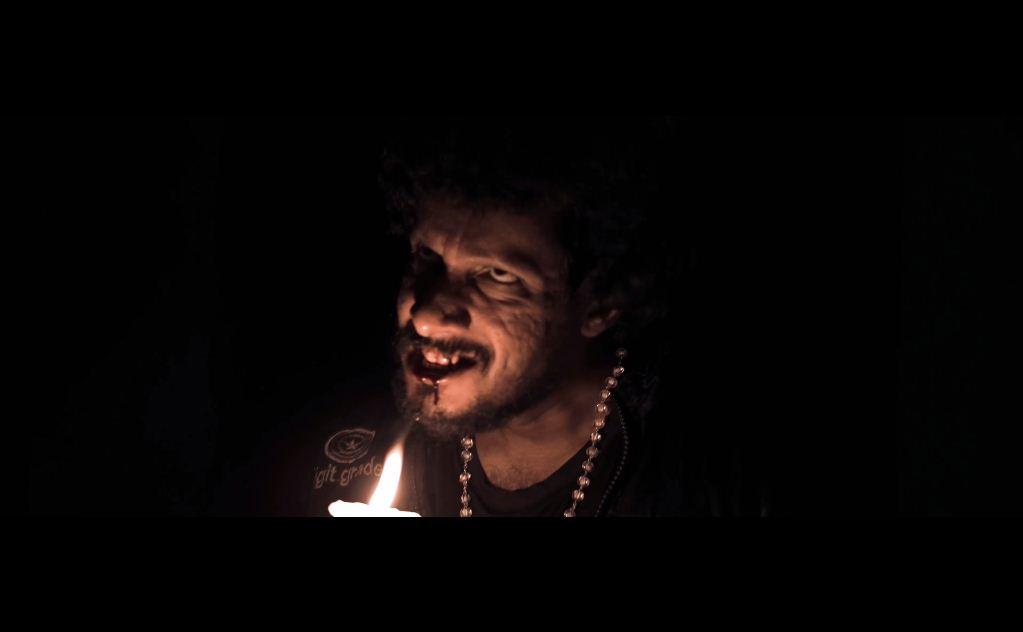 Man looks sinister behind candle in Paranormal Project