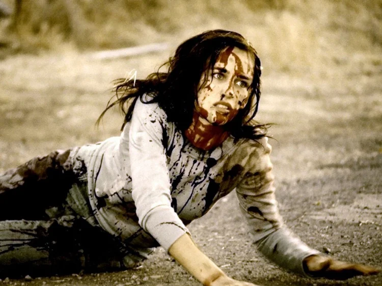 Young woman on ground bleeding and looking off screan at a threat in Babysitter Wanted