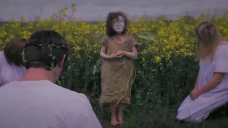 Girl in mask at edge of a field