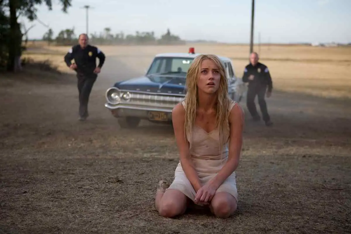 Kristen (Amber Heard) drops to her knees in John Carpenter's horror film The Ward.
