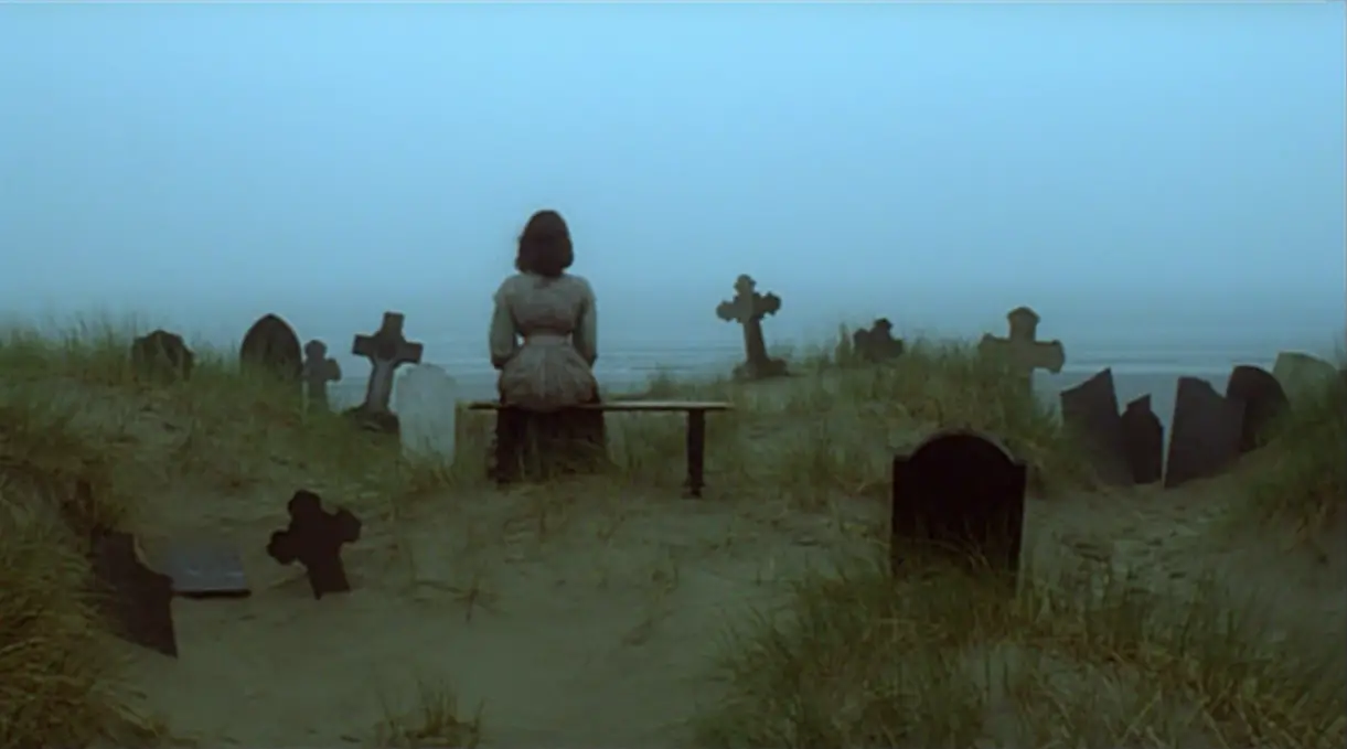 Lucy sits by the cemetery