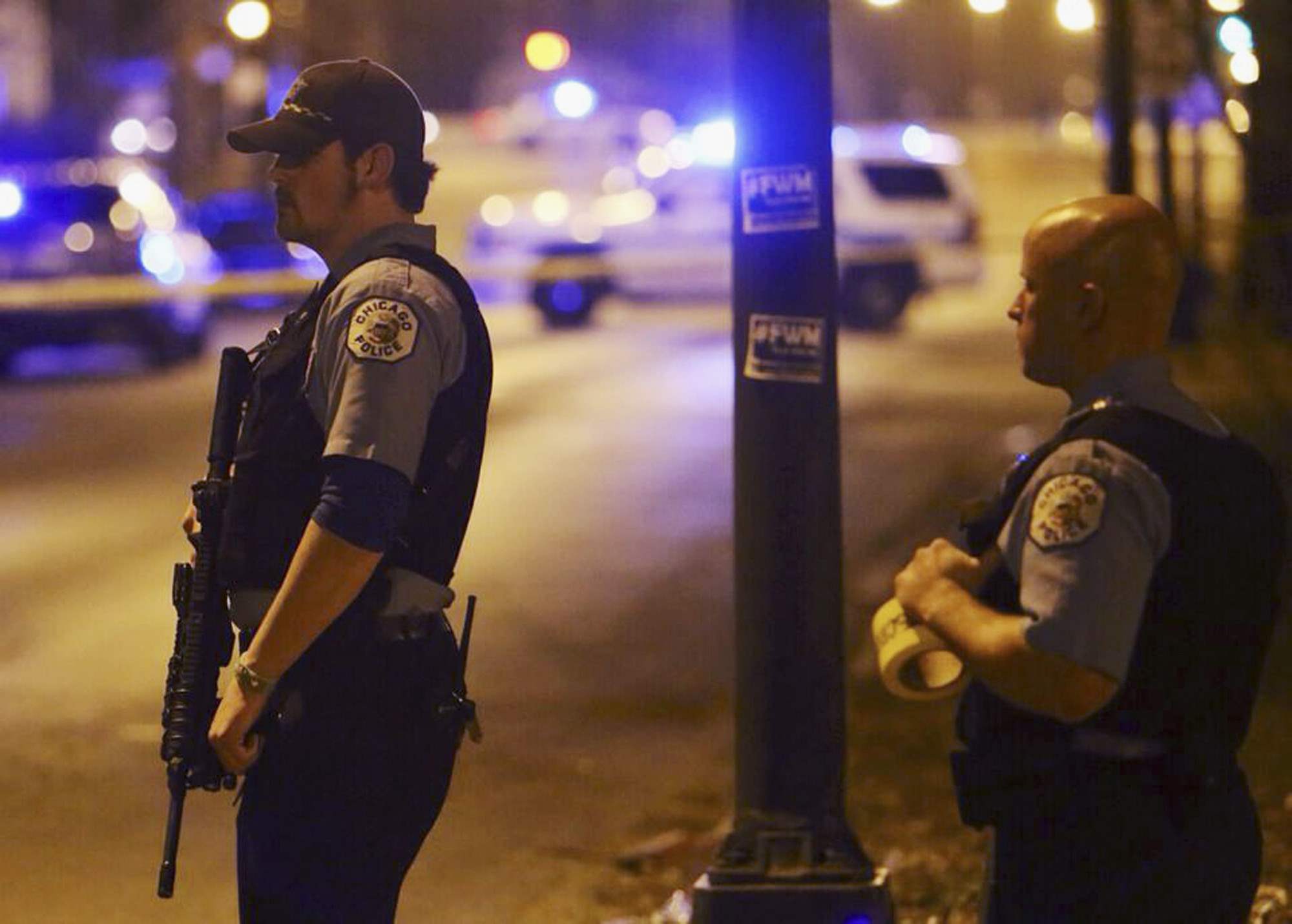 In this Sunday, April 20, 2014 photo, Chicago police stand guard at the scene where five children, all 15 years old or younger, were shot and wounded in Chicago. Police said Monday that eight people were killed and 44 injured, including the five children, in weekend shootings. (AP Photo/Sun-Times Media, Brian Jackson) MANDATORY CREDIT, MAGS OUT, NO SALES ** Usable by LA and DC Only **