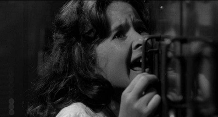 A panicked Nancy runs from Cady in the school in 1962's Cape Fear.