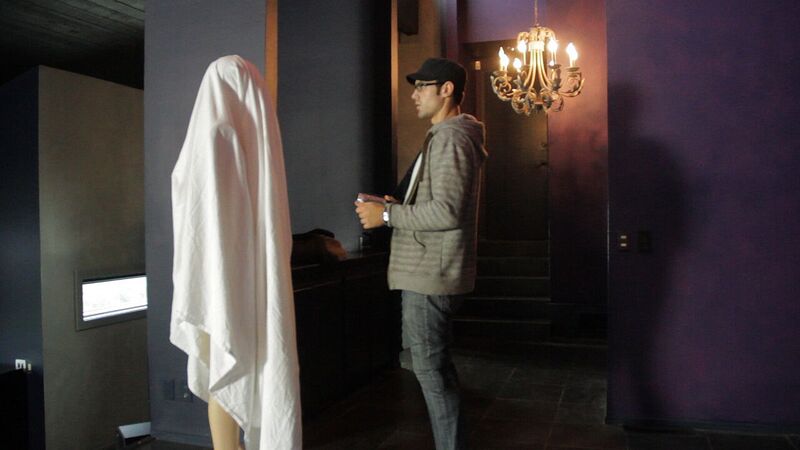 Andre inspects a mannequin covered in a sheet in It Watches